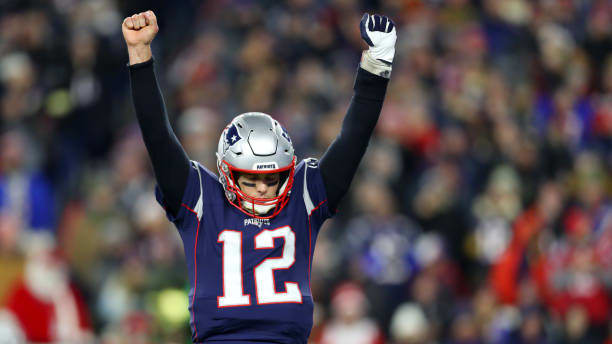 Former New England Patriots quarterback Tom Brady celebrates in the middle of a game.